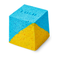 Salt Water Soother. A cube-shaped bath bomb with a split-colour design of bright blue and yellow. The top face features a debossed "LUSH" logo. The texture is coarse and granular with visible Epsom salt throughout.