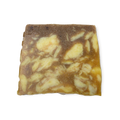 Sandstone. A sandy yellow coloured, trapezium shaped soap, with a roughly textured surface and bumps along its left side.
