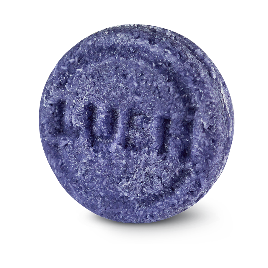Jumping Juniper. A circular, textured purple Lush solid shampoo bar, embossed with the brand name 'LUSH' across the centre, isolated against a solid black background.