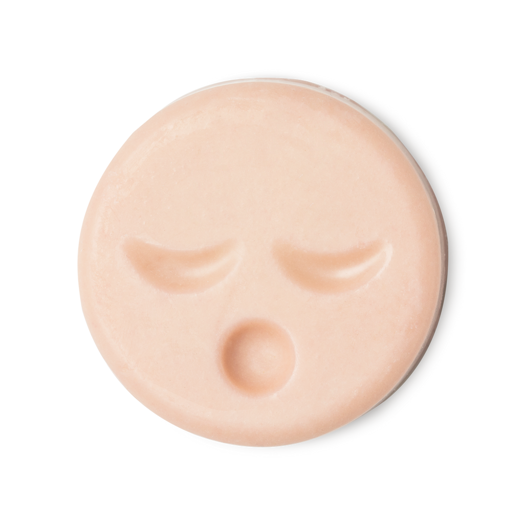 Sleepy Face. A circular, pale peachy pink naked cleansing balm, engraved with little yawning face.