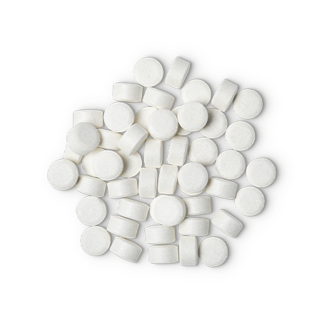 A pile of small, circular, white Sparkle toothpaste tabs shot from above.