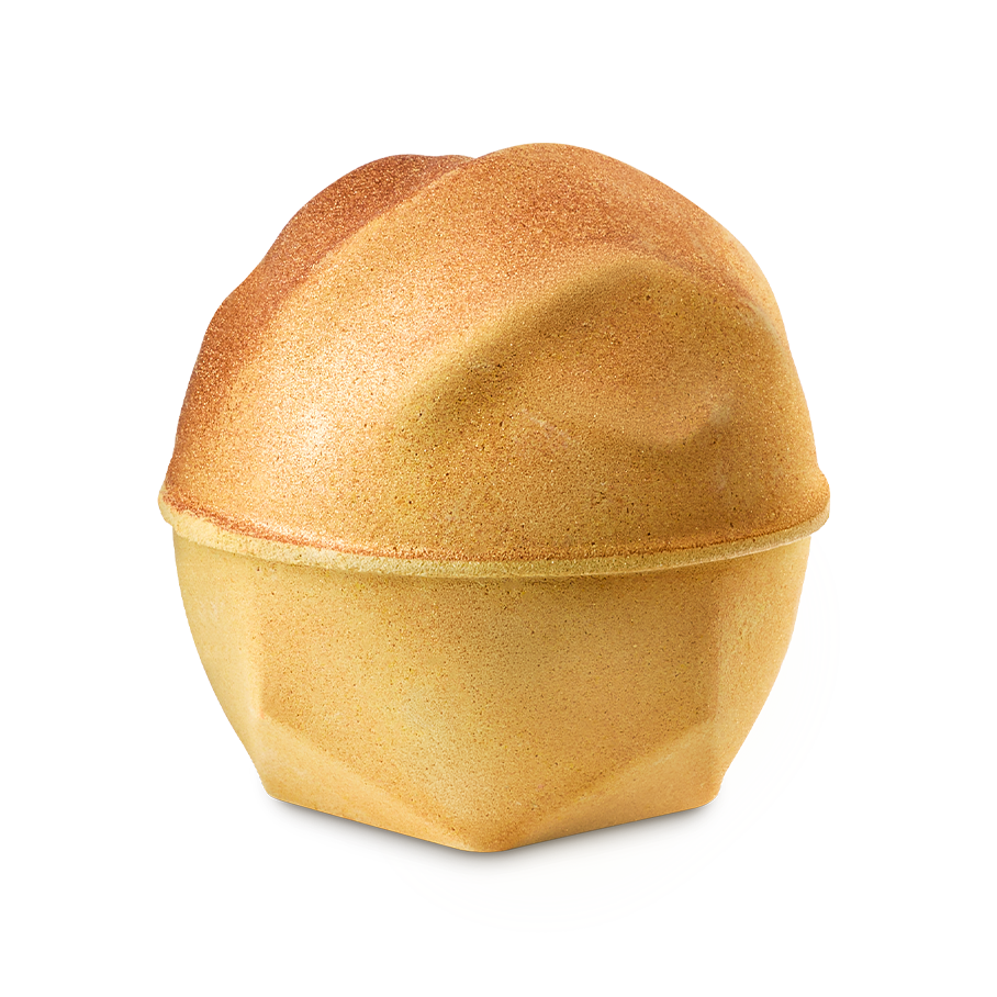 Sticky Dates. A golden, spherical bath bomb with a slightly rippled top half and a geometric base. The product is topped with shimmering, golden lustre.