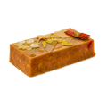 Sticky Syrup. A golden, caramel-coloured slab or rectangle soap with pressed, dried flowers on top.