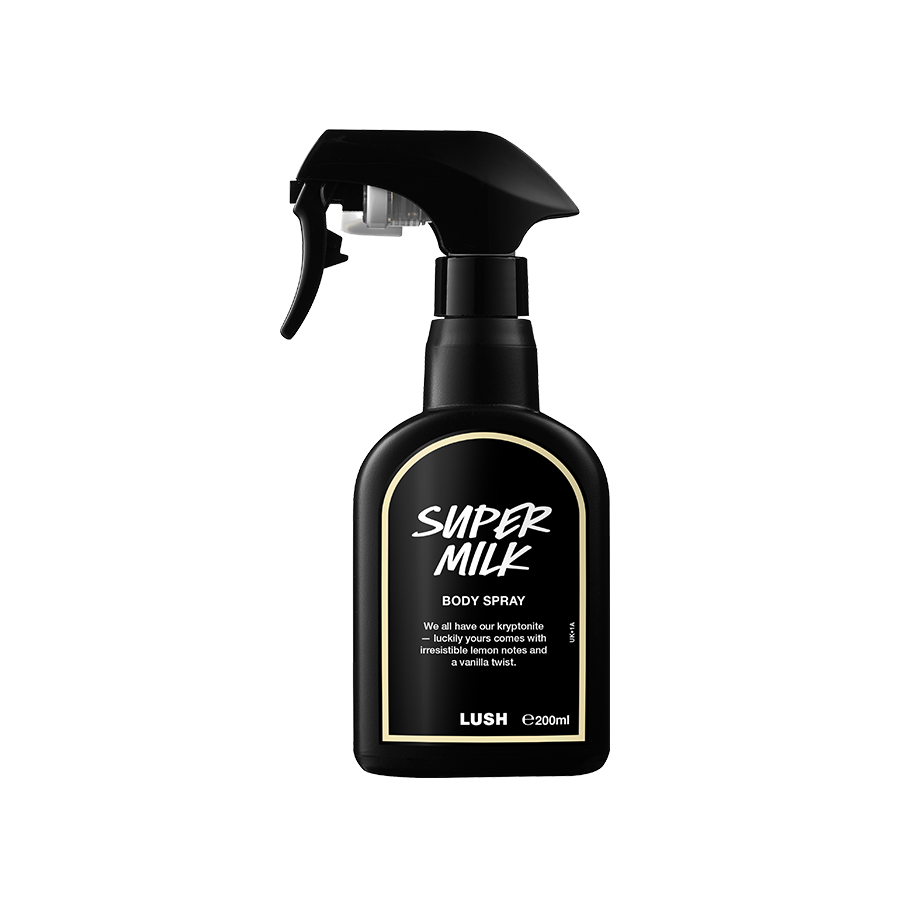 A recycled black plastic LUSH body spray bottle with a trigger nozzle stands upright with a creamy-yellow rimmed label with white text that reads "Super Milk Body Spray".
