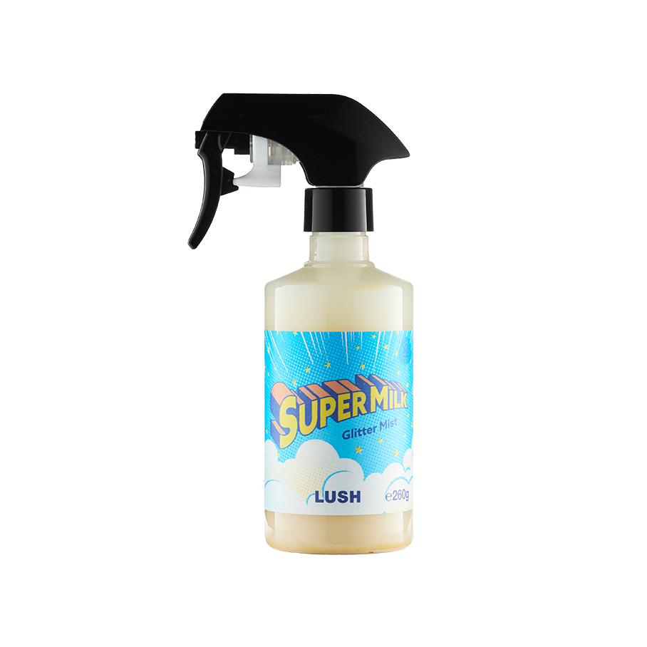 A bottle of Lush 'Super Milk' Glitter Mist. The clear bottle contains a cream-coloured liquid and features a black trigger spray nozzle. The bright blue label has clouds and bold yellow lettering.