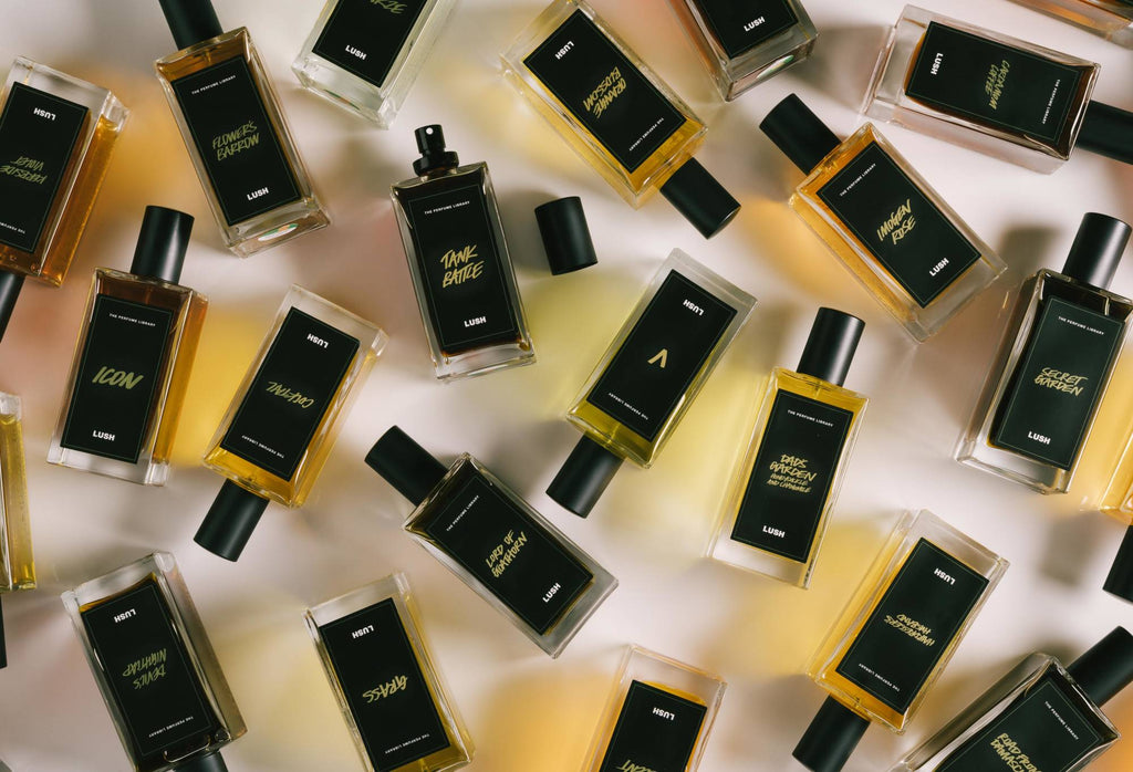 A number of black label perfume bottles are arranged randomly, with Tank Battle in the centre, lid off, ready to spritz.