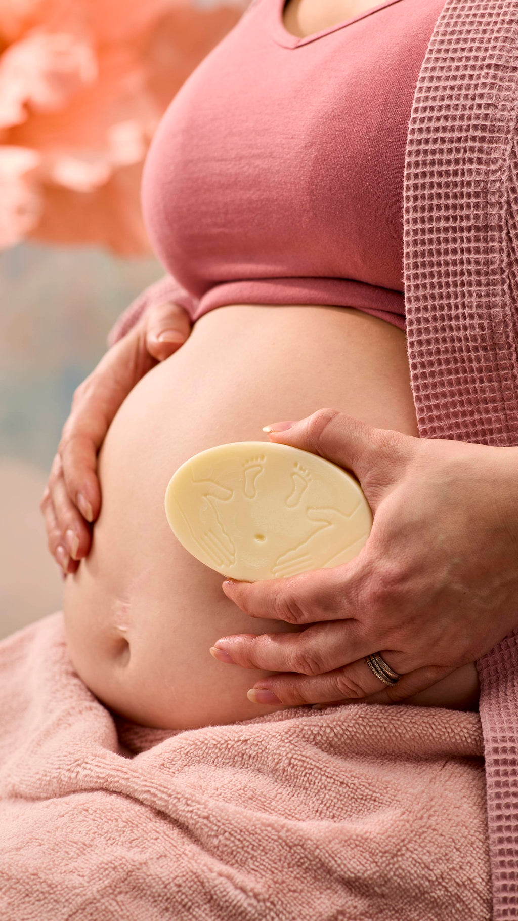 A close-up shot of the model's pregnant belly as they smooth over the moisturising The Bump solid massage bar over this skin.