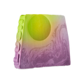 To The Moon and Back. An off-square slice of soap with a sunset-inspired design. The top features a lime green circle, resembling a sun, which gradients into a swirling, marbled purple base. The word "LUSH" is embossed vertically down the side.