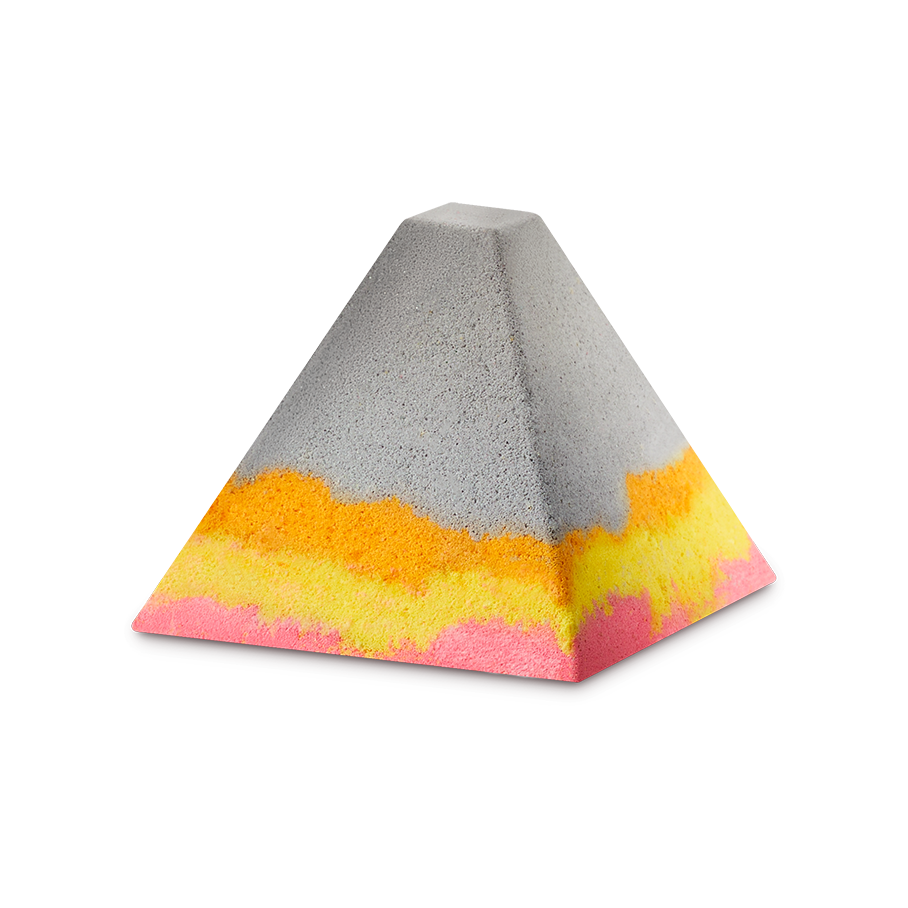 Volcano. A grey, pyramid-shaped bath bomb-style foot soak. The base features layered, wavy bands of vibrant orange, yellow, and bright pink, creating a colourful contrast against the neutral grey upper half.