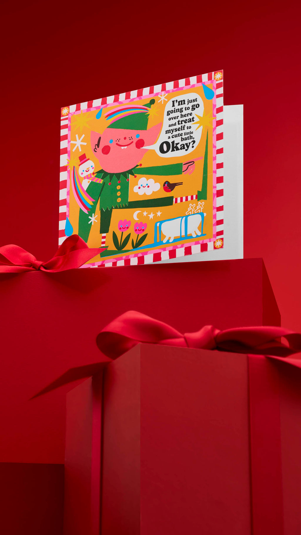 A festive "Treat Your Elf" greeting card with a whimsical elf standing next to a bathtub and saying, "I'm just going to go over here and treat myself to a calming bath. Okay?" The card is displayed on a red background with wrapped gifts.
