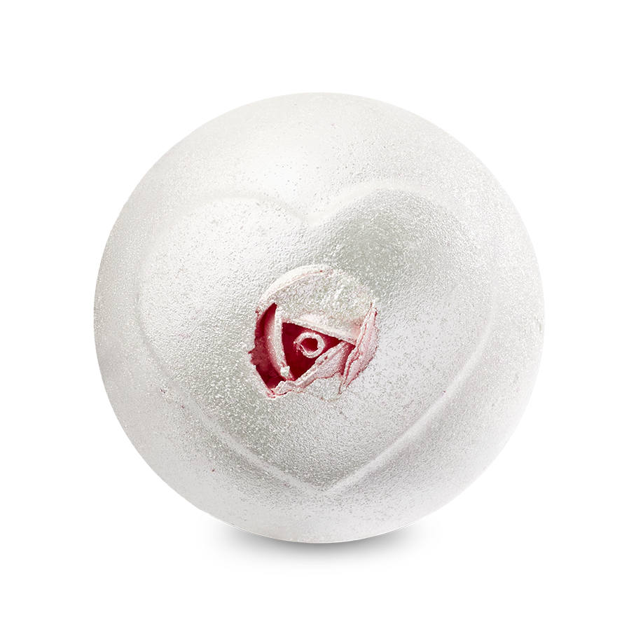 A top-down view of the Wedding bath bomb depicts a shimmering, pearlescent white sphere against a solid black background. An embossed heart shape on the surface reveals a realistic pink rosebud inside its center.